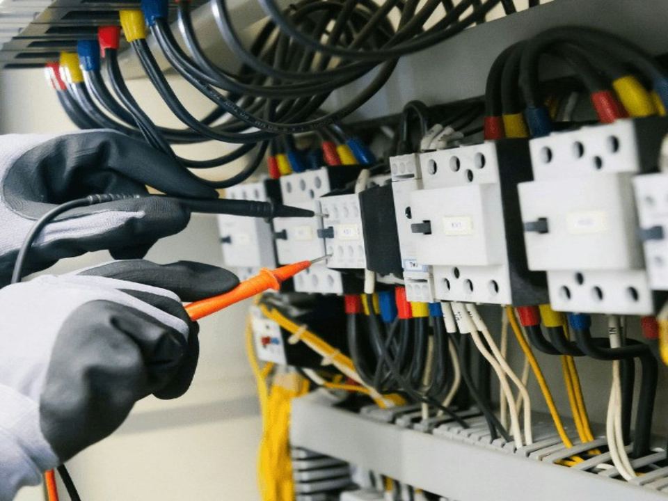 An electrician testing a panel with a multimeter